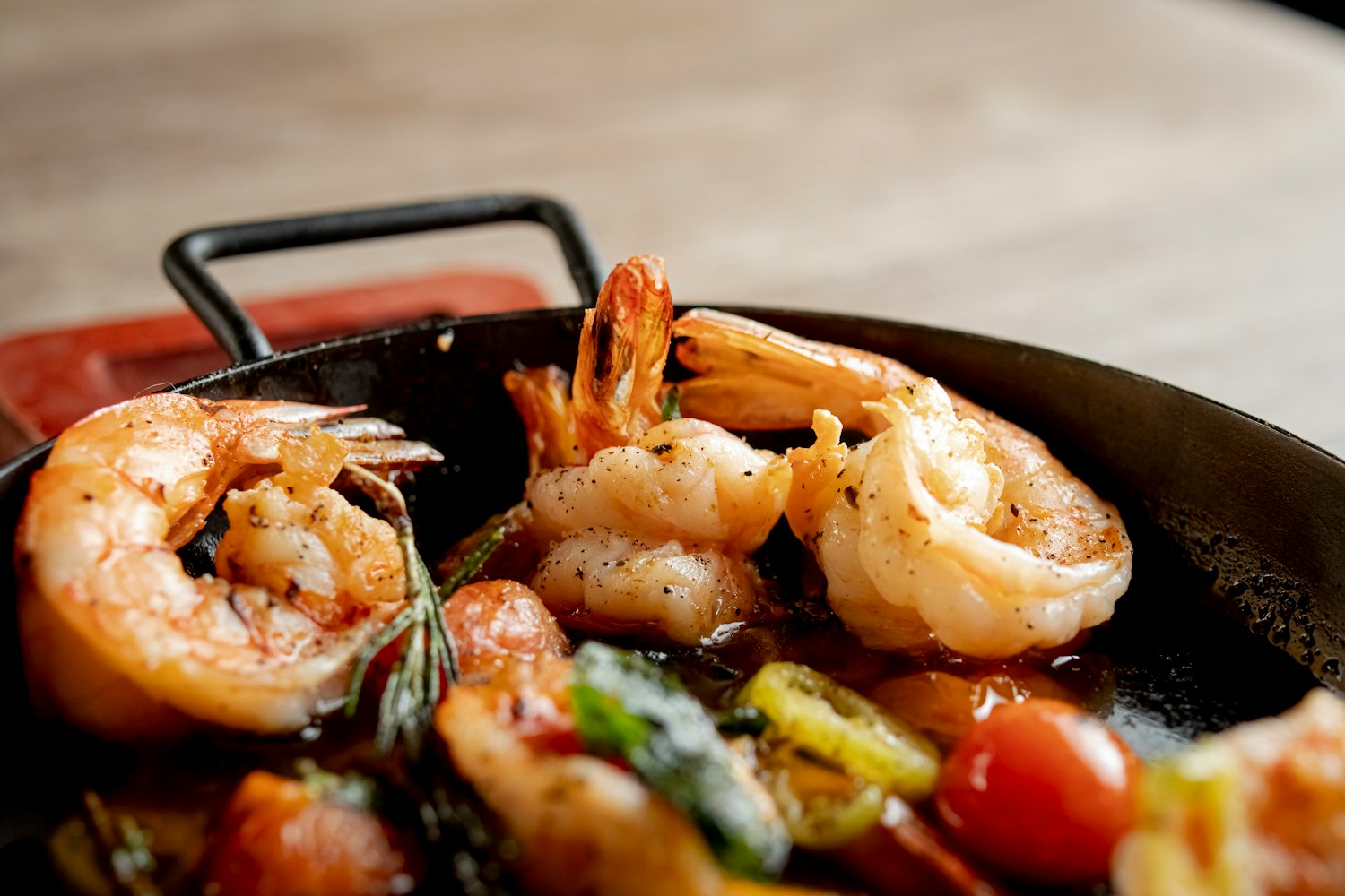 Shrimp cooked with tomatoes and herbs in a black pan