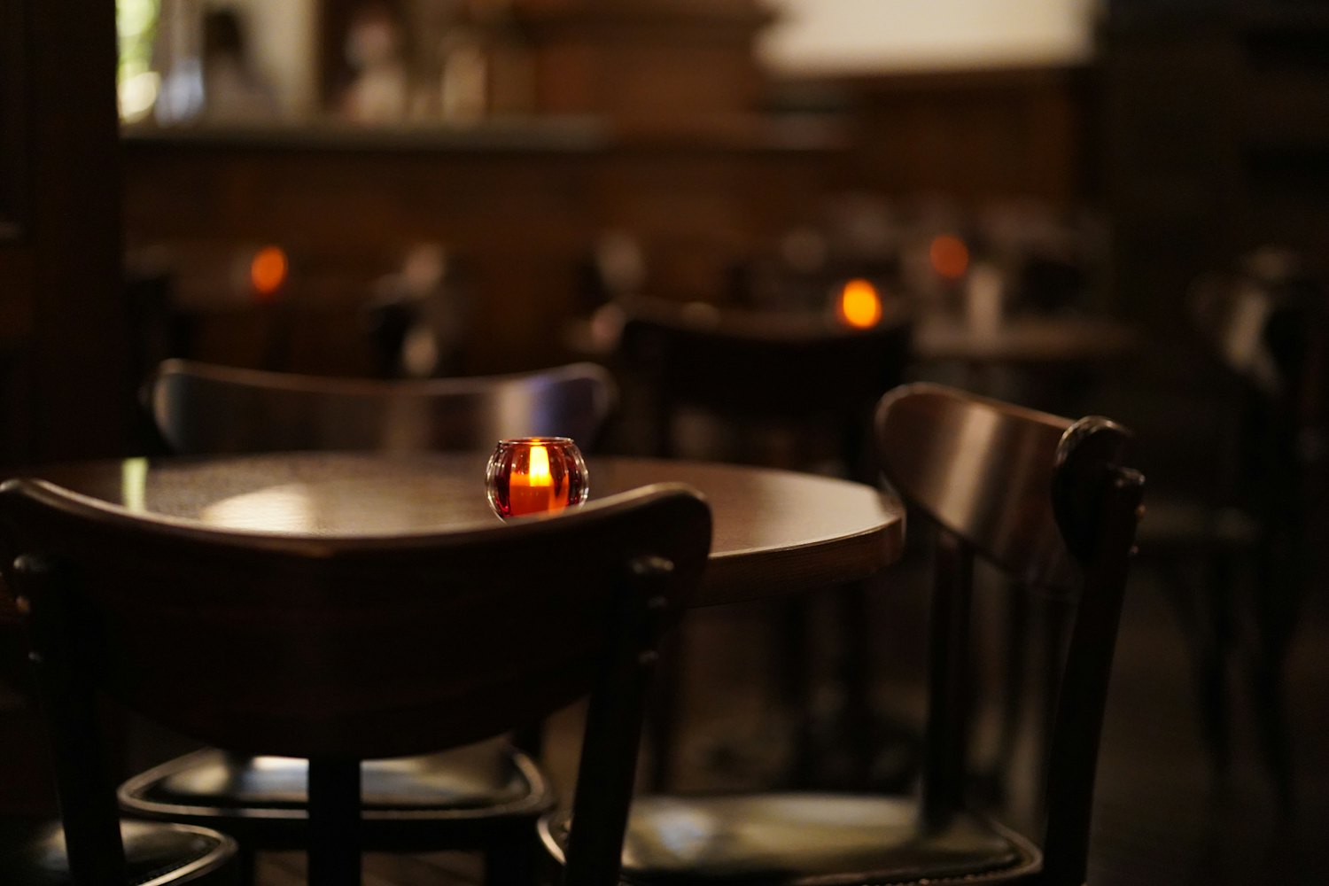 A candle-lit table in a warm, dark dining room